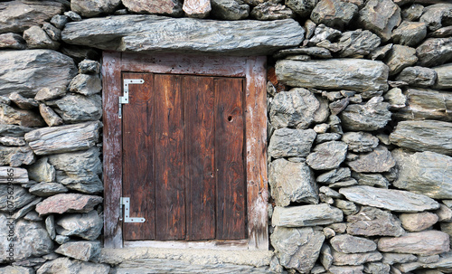 geschlossenes Holzfenster an einem Steinhaus - closes wooden door in a stone house photo