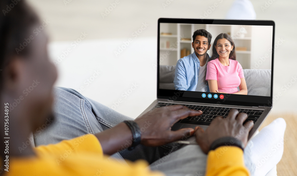A person sits comfortably on a sofa, engaging in a video call with two smiling friends. The bright room enhances the warm atmosphere of their conversation filled with laughter. A person sits comfortably on a sofa, engaging in a video call with two smiling friends. The bright room enhances the warm atmosphere of their conversation filled with laughter.