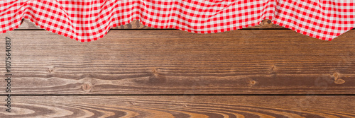 Red folded tablecloth on an old wooden table. Close up photo