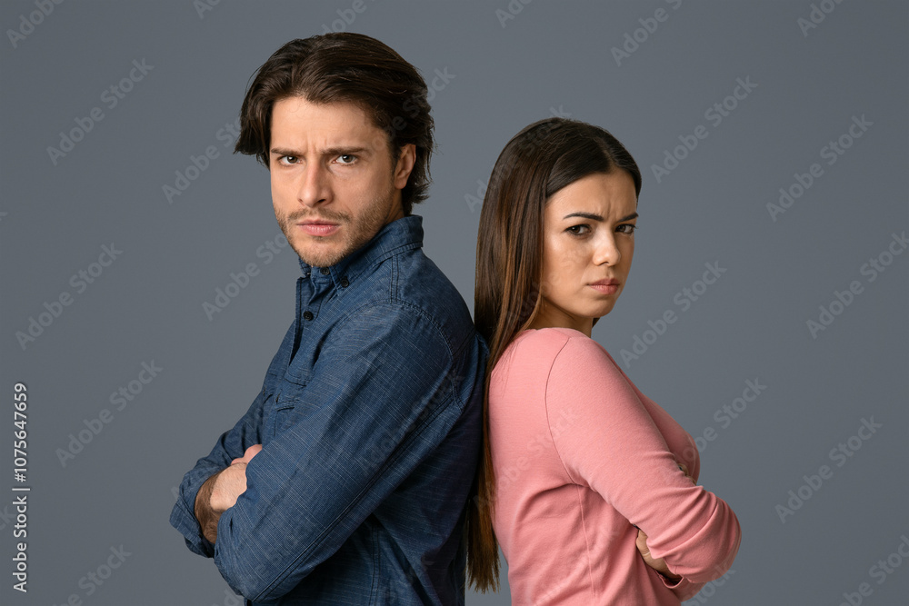 Relationship Crisis. Offended young couple standing back to back with folded arms and looking at camera, light studio background with copy space Relationship Crisis. Offended young couple standing back to back with folded arms and looking at camera, light studio background with copy space