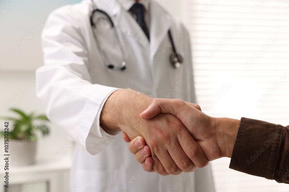 Doctor shaking hands with patient in hospital, closeup Doctor shaking hands with patient in hospital, closeup