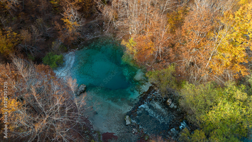Natural blue hole karst source Oko Skakavice in Montenegro, Europe in autumn season. Aerial view of beautiful mountain lake with clear turquoise water. Prokletije National Park. Natural blue hole karst source Oko Skakavice in Montenegro, Europe in autumn season. Aerial view of beautiful mountain lake with clear turquoise water. Prokletije National Park.