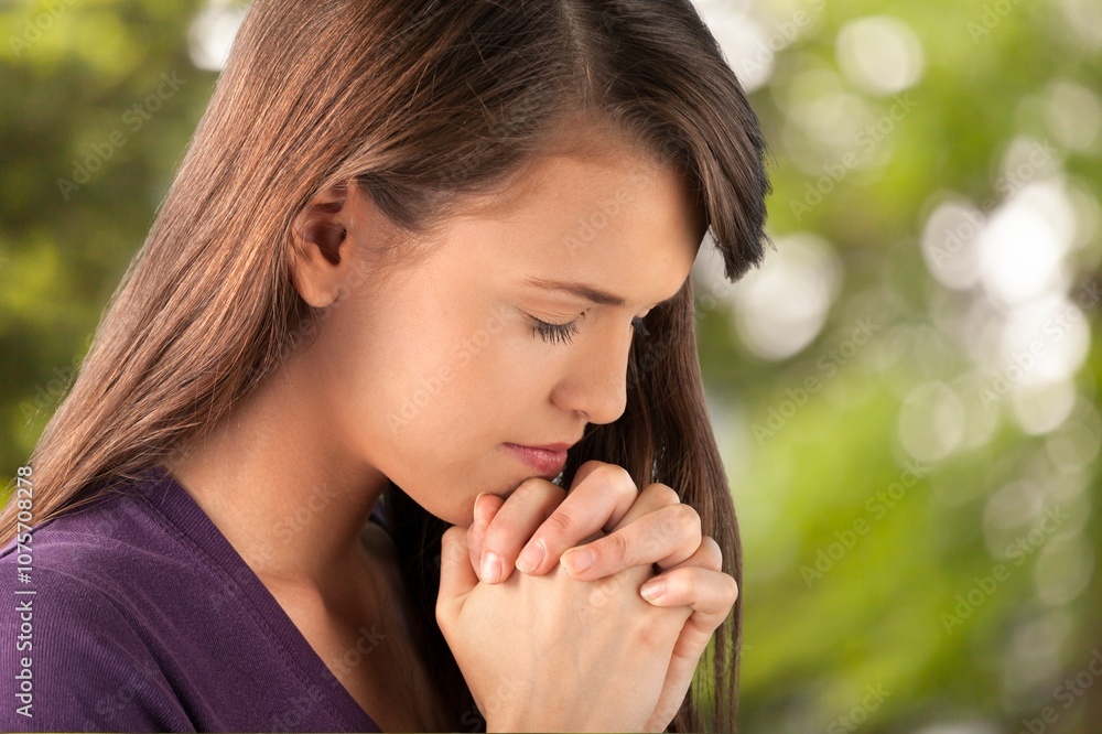 Young woman praying to god on nature background Young woman praying to god on nature background