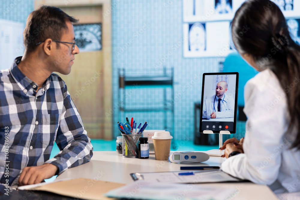 Indian physician entering a video call with expert to discuss diagnostic report, asking the specialist for a second opinion on remote videoconference. Doctors meeting online for telehealth. Indian physician entering a video call with expert to discuss diagnostic report, asking the specialist for a second opinion on remote videoconference. Doctors meeting online for telehealth.
