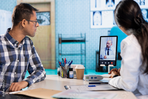 Indian physician entering a video call with expert to discuss diagnostic report, asking the specialist for a second opinion on remote videoconference. Doctors meeting online for telehealth. photo