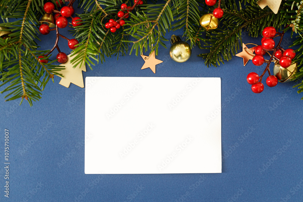 Empty greeting card and fir branches, red berries, gold ornaments on blue background flat lay. Christmas card mockup with space for text. Xmas Postcard. Season greetings card template Empty greeting card and fir branches, red berries, gold ornaments on blue background flat lay. Christmas card mockup with space for text. Xmas Postcard. Season greetings card template