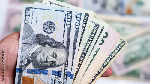 Hand holding a variety of US dollar bills in fanned view