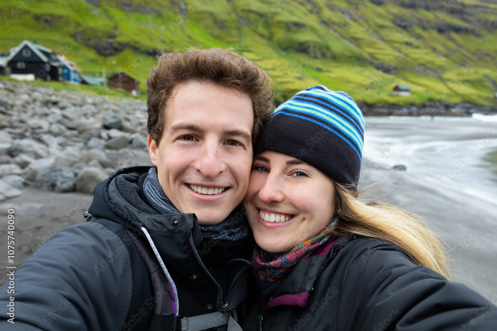 Traveler Couple Sharing a Kiss at Tjørnuvik Beach, Faroe Islands Traveler Couple Sharing a Kiss at Tjørnuvik Beach, Faroe Islands