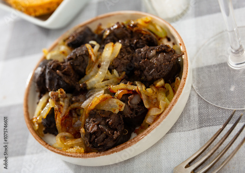 Canvastavla Spanish blood sausage morcilla served with grilled onion on plate