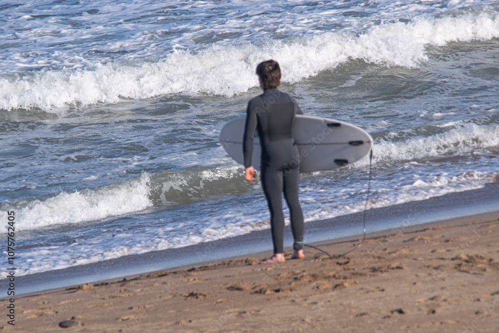 Surfer on the beach , looking at the waves Surfer on the beach , looking at the waves