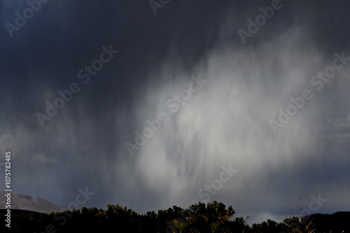 Rain squalls dropping from dark clouds, Highway 395, Topaz, Nevada