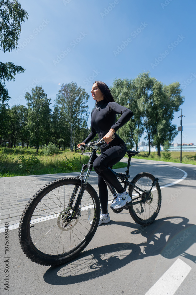 Caucasian woman riding a bike in a park. Vertical photo. Caucasian woman riding a bike in a park. Vertical photo.