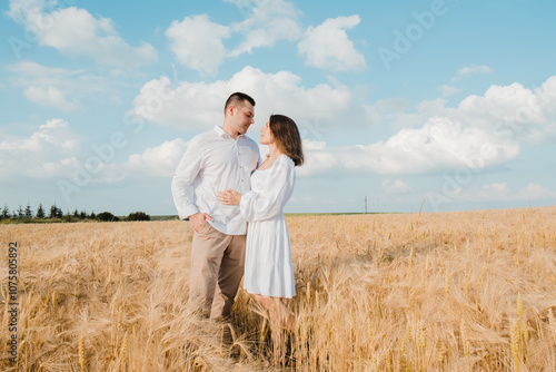 A man and a woman in wheat, two hugging and kissing. Honeymoon