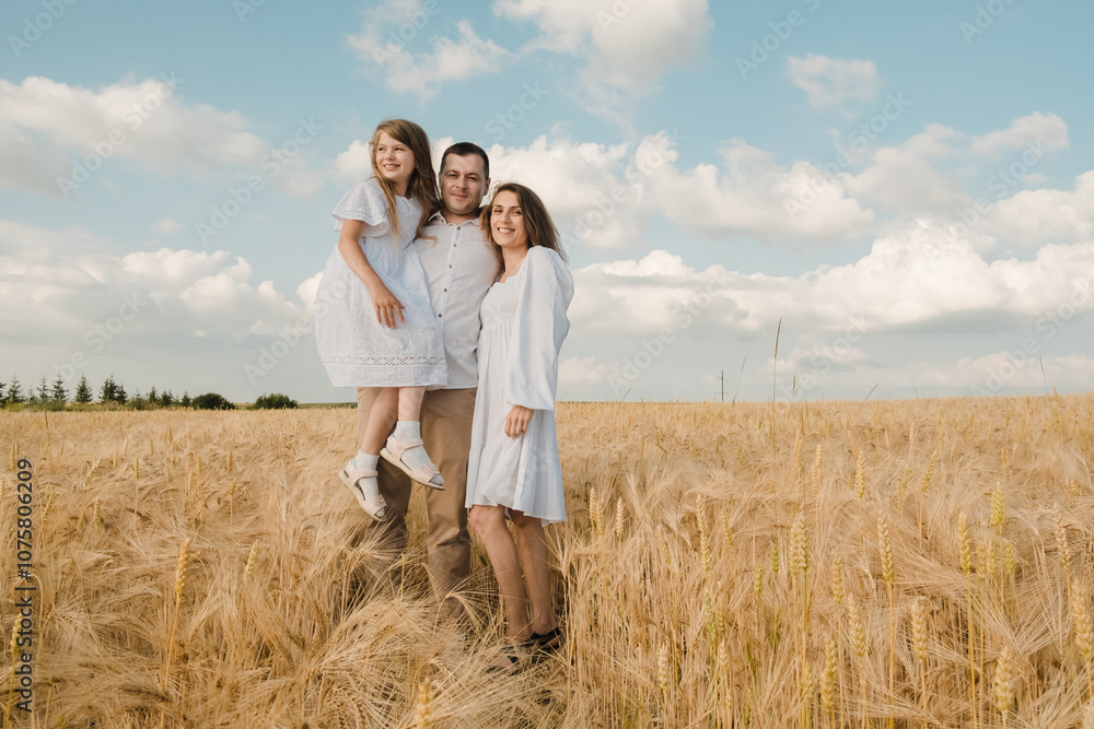 farmer carries little daughter in his arms through a field of wheat. happy child and father are playing in field of ripening wheat.Beautiful family in the park. farmer carries little daughter in his arms through a field of wheat. happy child and father are playing in field of ripening wheat.Beautiful family in the park.