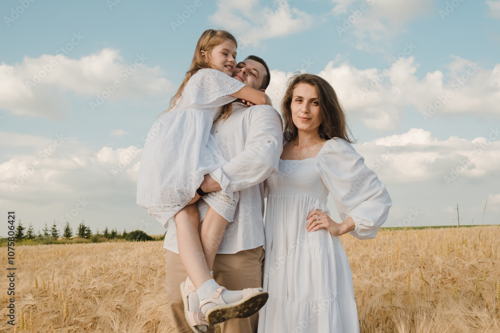 A sincere family in the park. Dad holds his daughter in his arms. Family in a wheat field. A sincere family in the park. Dad holds his daughter in his arms. Family in a wheat field.