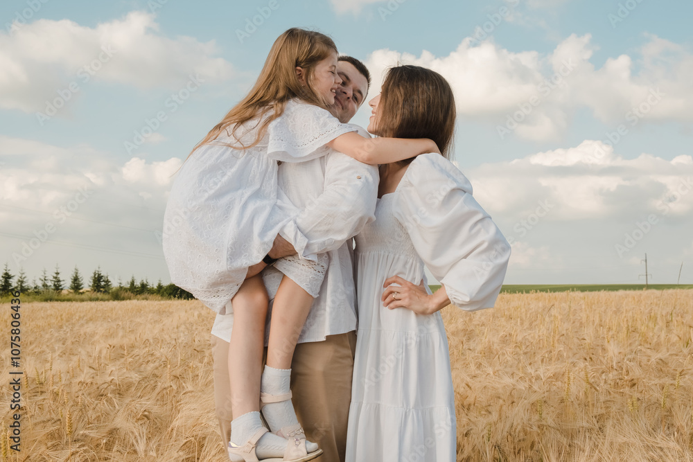 Cheerful family in the park. Dad holds his daughter in his arms. Cheerful family in the park. Dad holds his daughter in his arms.
