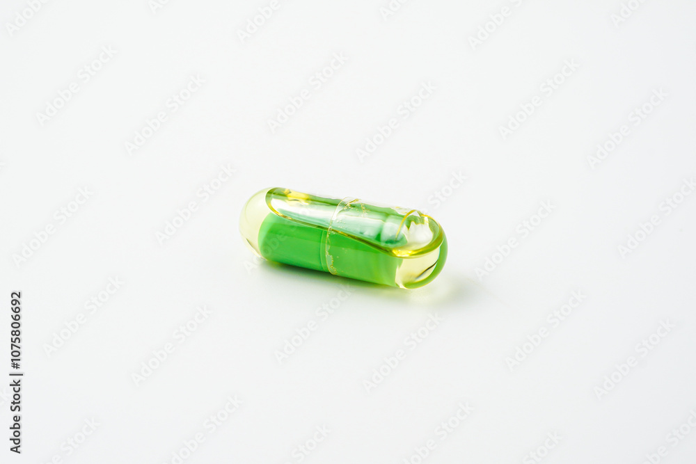 Transparent capsules with a mixture of green powder and oil, Food supplements, vitamins Transparent capsules with a mixture of green powder and oil, Food supplements, vitamins