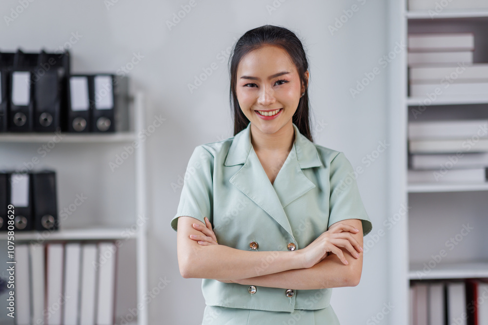 Portrait of successful confident pretty, young asian business woman or freelancer standing near work desk in office, wearing formal stylish clothes, arms crossed, looking at camera, smiling friendly Portrait of successful confident pretty, young asian business woman or freelancer standing near work desk in office, wearing formal stylish clothes, arms crossed, looking at camera, smiling friendly