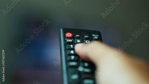 TV remote with red power button, focus selected, blurred background and foreground