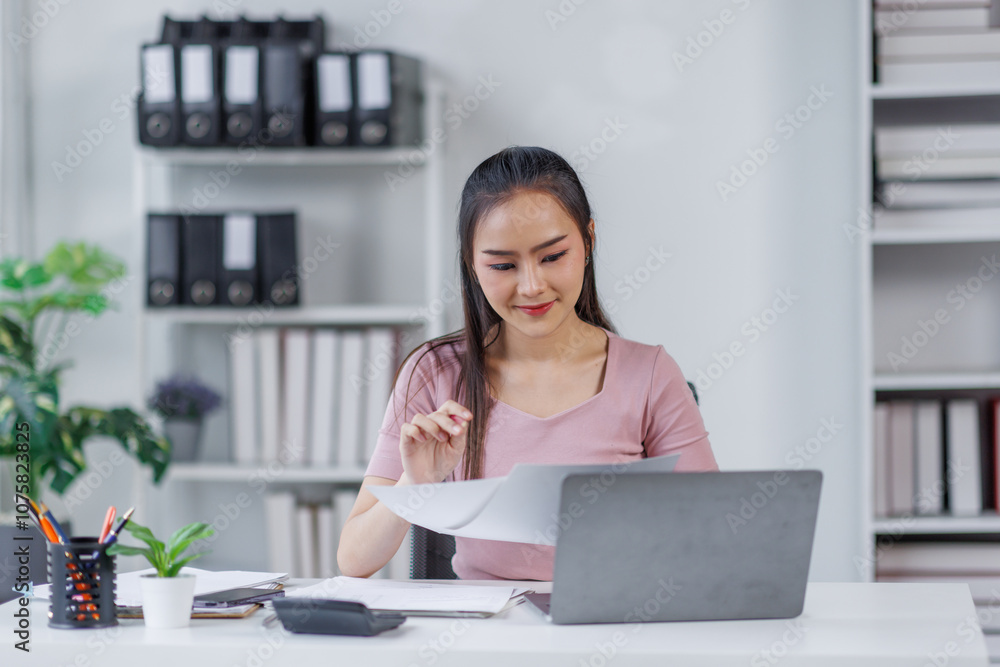 Asian Businesswoman Using laptop computer and working at office with calculator document on desk, doing planning analyzing the financial report, business plan investment, finance analysis concept.
Asian Businesswoman Using laptop computer and working at office with calculator document on desk, doing planning analyzing the financial report, business plan investment, finance analysis concept.
