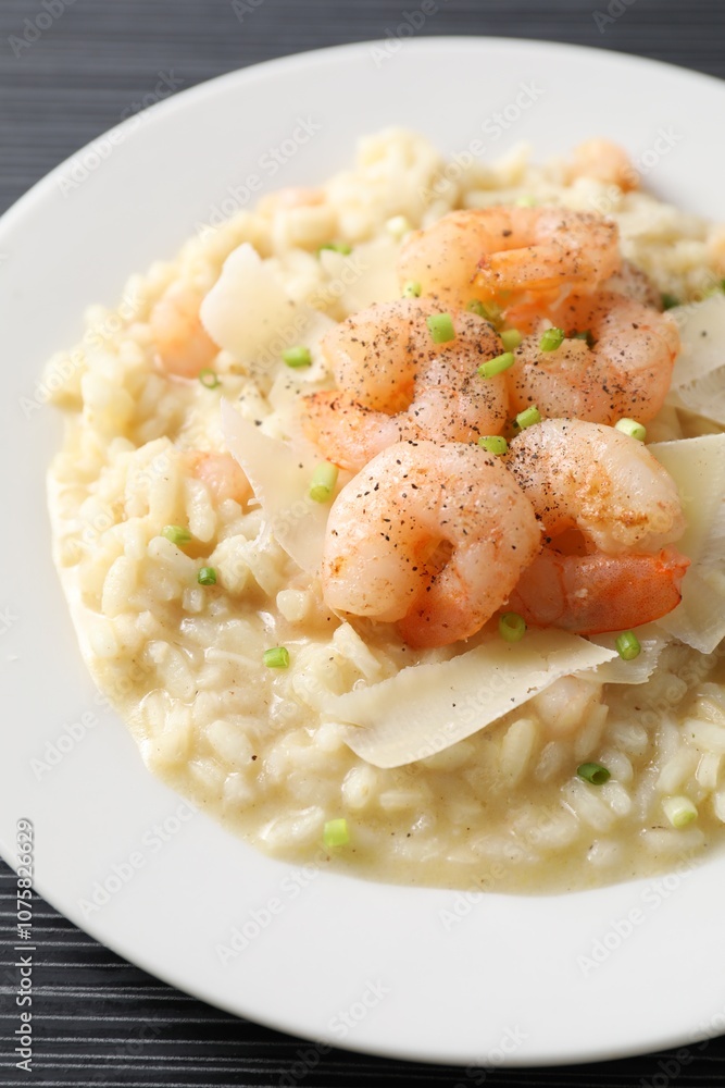Delicious risotto with shrimps and cheese on black table, closeup Delicious risotto with shrimps and cheese on black table, closeup