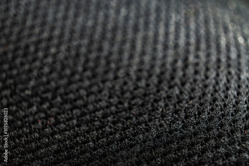 Close-up detail of textured shoe surface set against a dark background highlighting its unique weave