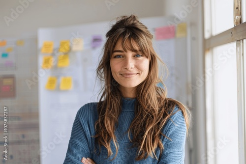 Smiling Woman in Blue Sweater Standing in Minimalist Office with Sticky Notes