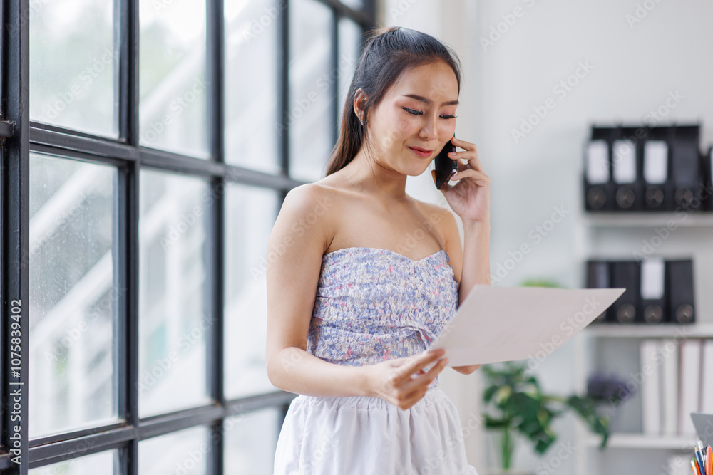 Cheerful business Asian woman freelancer making telephone call share good news about project working in office workplace, business finance concept.
Cheerful business Asian woman freelancer making telephone call share good news about project working in office workplace, business finance concept.