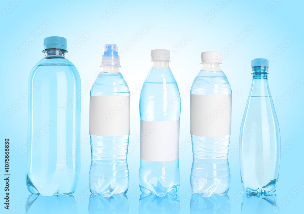 Different plastic bottles with water on light blue background Different plastic bottles with water on light blue background