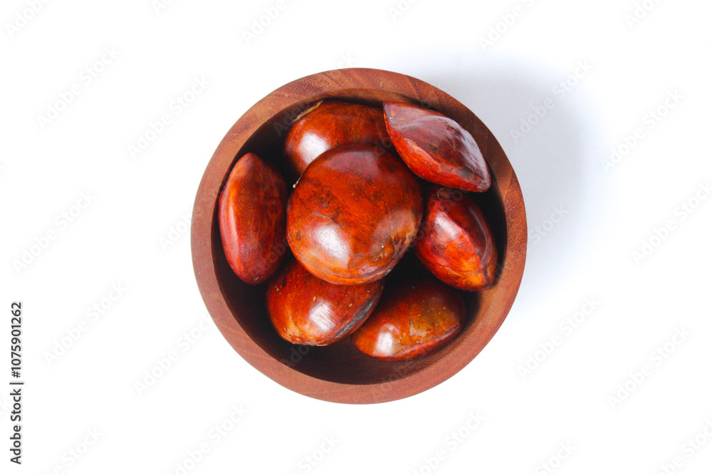 Obraz premium Dogfruit (Archidendron pauciflorum) an Indonesia commonly called djenkol, jengkol or jering on a small wooden bowl isolated on white background. Food Ingredients