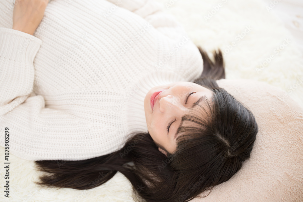 仰向けで目を閉じる女性 お昼寝や睡眠のイメージ 仰向けで目を閉じる女性 お昼寝や睡眠のイメージ