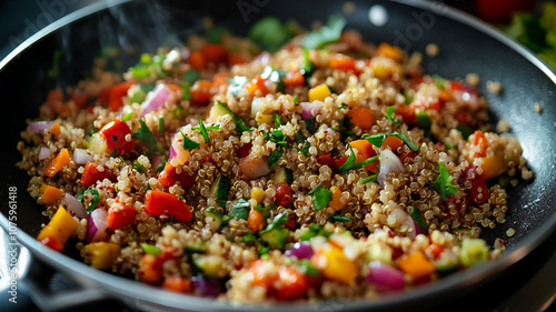 Colorful quinoa salad being prepared in a skillet with fresh vegetables and herbs