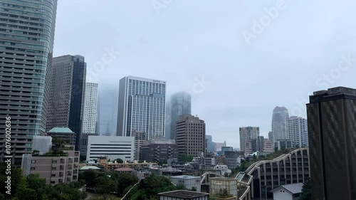 Foggy morning view of Tokyo's Azabudai Hills skyscrapers rising above the cityscape photo