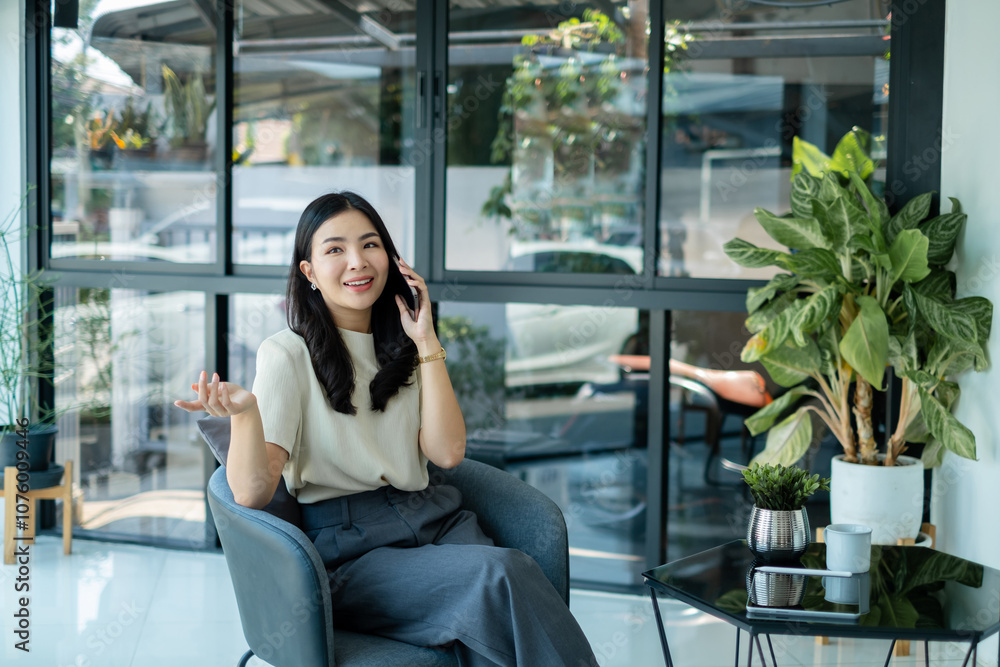 Young Asian woman talking on the mobile phone working on smartphone In modern office Young Asian woman talking on the mobile phone working on smartphone In modern office