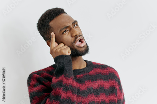 Curious man in red and black sweater listening intently with hand to ear for important sound photo