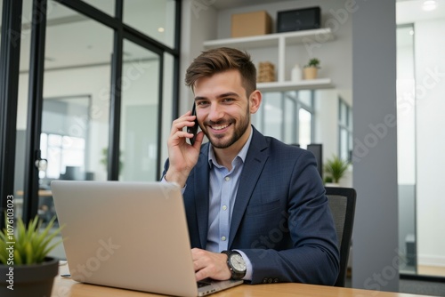 Professional Man in Business Suit Using Laptop and Phone in Modern Office Setting, Ideal for Business Marketing and Corporate Branding