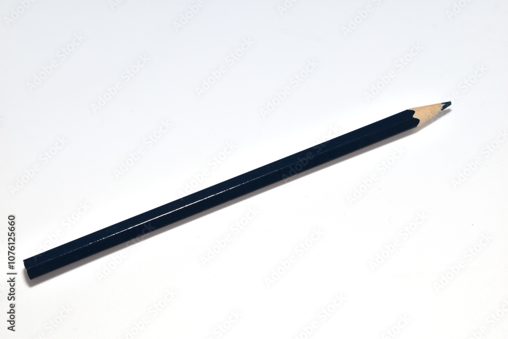 A simple black pencil lies on a white background. A simple black pencil lies on a white background.