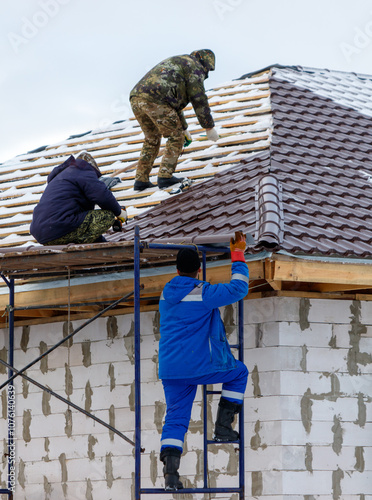 Wallpaper Mural Three men are working on a roof, one of them is wearing a blue jacket Torontodigital.ca