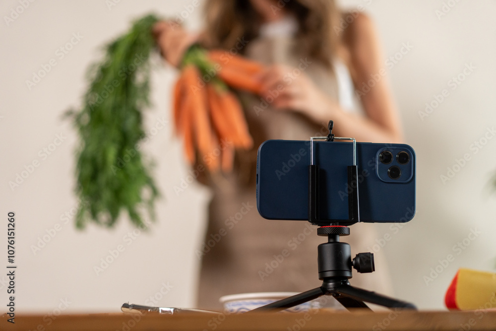 Obraz premium Content creator filming smartphone recipe fresh vegetables carrots healthy food vlog social video recording tripod