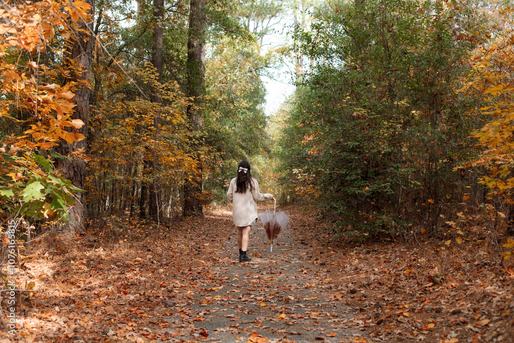 Fototapeta premium Woman enjoying a Fall walk in the forest
