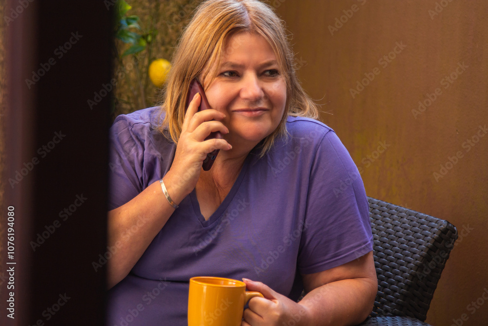 Senior woman relaxing on terrace with mobile phone and cup Senior woman relaxing on terrace with mobile phone and cup