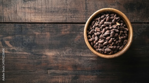 Cacao nibs arranged in a bowl placed on a rustic wooden table, offering a natural and organic aesthetic. The cacao nibs bring a touch of earthiness to the scene with ample copy space.