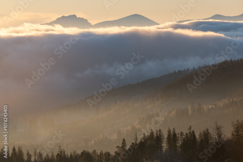 Fotografie Panorama of mountain peaks above inversion with sunrise and morning frost in Bes