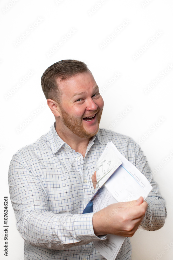 A cheerful Caucasian man joyfully tears a document, symbolizing debt relief and financial freedom on Tax Day A cheerful Caucasian man joyfully tears a document, symbolizing debt relief and financial freedom on Tax Day