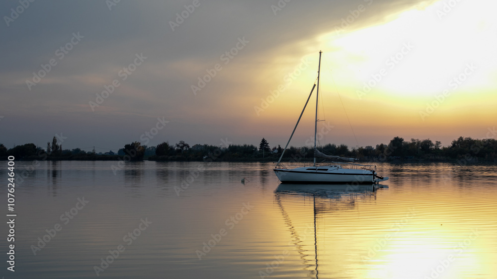 A serene sailboat is reflected in calm waters at sunset, capturing tranquility and adventure, ideal for summer leisure A serene sailboat is reflected in calm waters at sunset, capturing tranquility and adventure, ideal for summer leisure