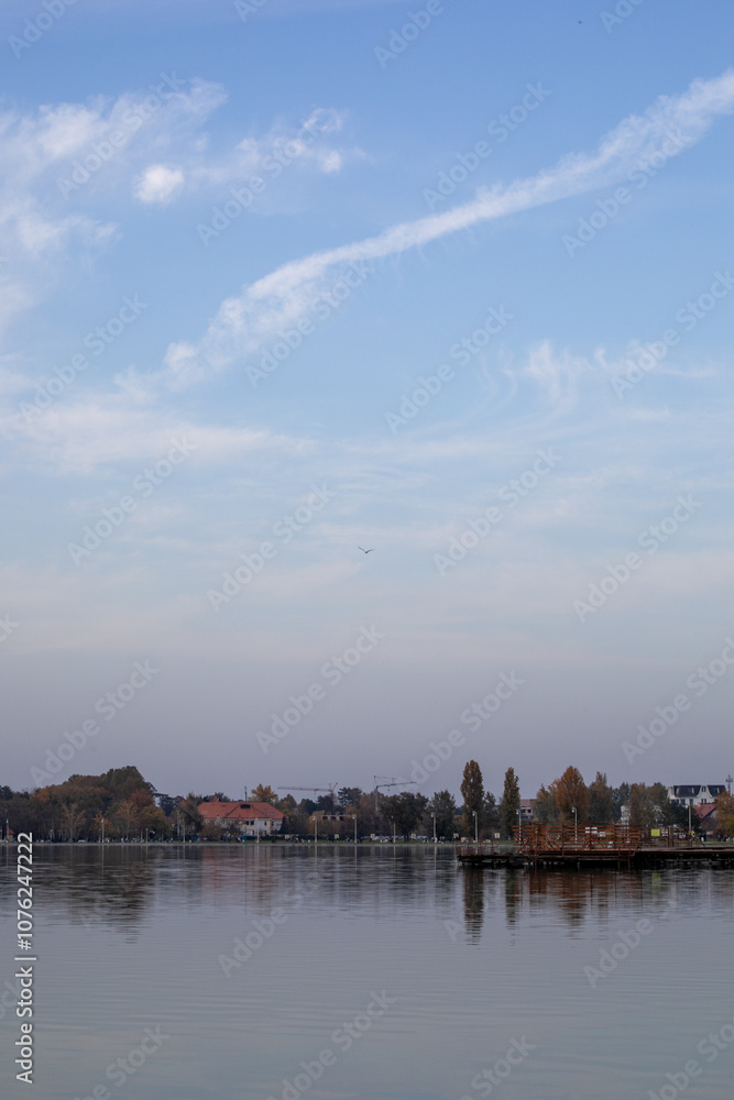 Tranquil lake scene with clear sky and autumn foliage, perfect for relaxation and mindfulness concepts Tranquil lake scene with clear sky and autumn foliage, perfect for relaxation and mindfulness concepts