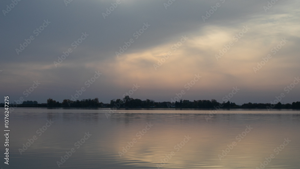 Tranquil sunset over a serene lake with distant trees, evoking relaxation and contemplation, perfect for promoting mindfulness Tranquil sunset over a serene lake with distant trees, evoking relaxation and contemplation, perfect for promoting mindfulness