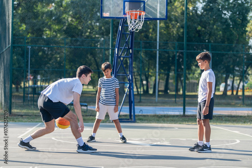 Boys participate in outdoor basketball training with a coach, focusing on skill development, teamwork, and fitness in a fun, structured environment, enhancing their athletic skills and confidence