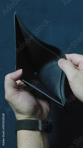Man revealing an empty wallet, illustrating financial hardships and economic challenges