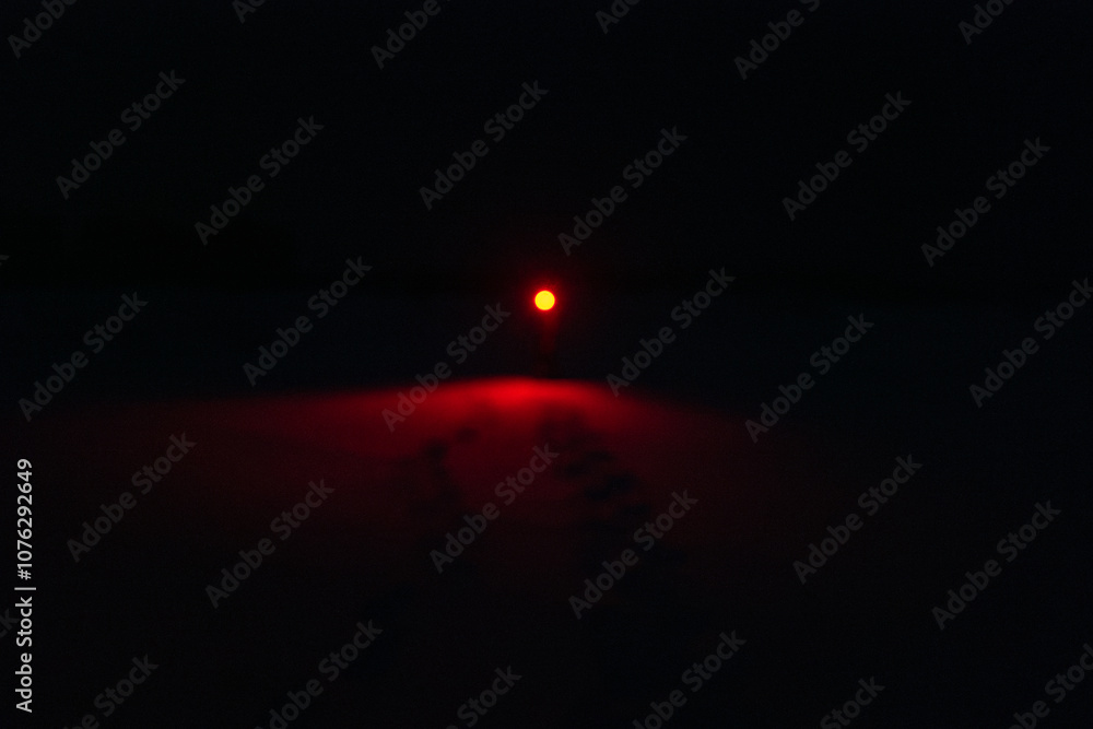 A Person in the Snow Shining a Creepy Red Flashlight in the Dark Night